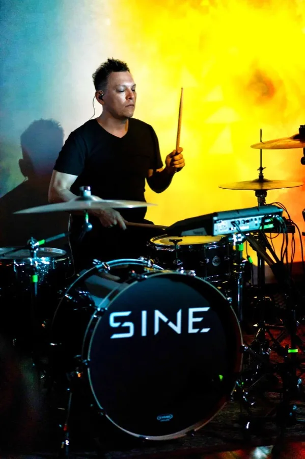 Sonny Sanchez playing drums under stage lights