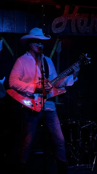 On stage in a cowboy hat with an Explorer guitar